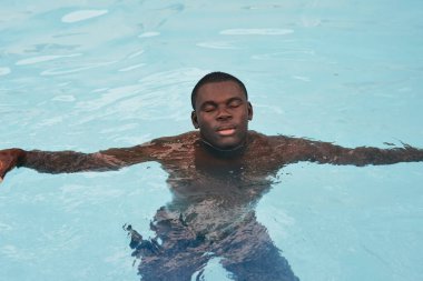 Havuzda poz veren genç yakışıklı adam.