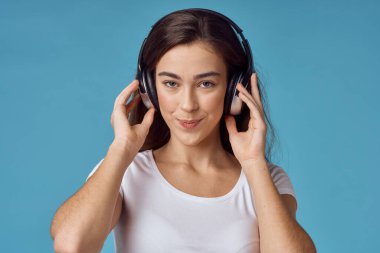 Kulaklıklı genç bir kadın müzik dinliyor.