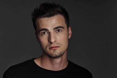 Stüdyoda poz veren genç yakışıklı adam.