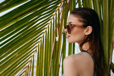 Genç ve güzel bir kadın sahilde dinleniyor.