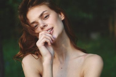 Yaz bahçesinde poz veren güzel bir kadın. 