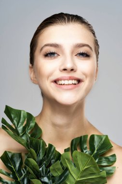 Stüdyoda yapraklarla poz veren genç ve güzel bir model.