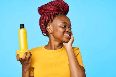  Afrikalı kadın izole edilmiş arka planda kozmetik sunumu yapıyor.