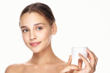 Genç ve güzel bir kadın krem tutuyor. 