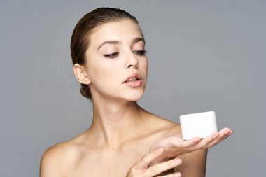 Kremalı güzel bir kadının stüdyo fotoğrafı, izole edilmiş bir arka planda güzellik ürünü.