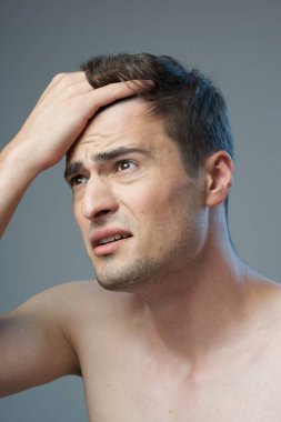 Stüdyo çekimi. Modern saç stili olan genç yakışıklı bir adam stüdyoda poz veriyor. 