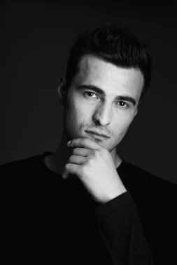 Stüdyoda düşünen yakışıklı bir genç. 