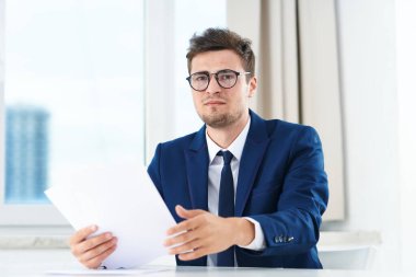 Ofisinde belgeleri olan yakışıklı bir iş adamı. 