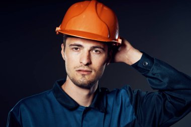 Şapkalı genç işçi poz veriyor