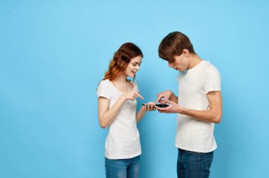 Stüdyoda akıllı telefonları olan genç adam ve kadın. 