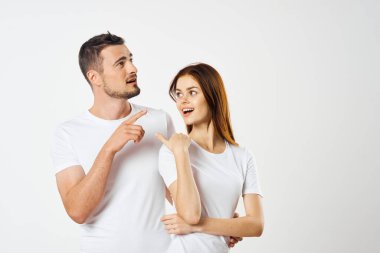 Genç çift izole edilmiş arka planda stüdyoyu işaret ediyor.