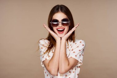 Stüdyoda poz veren güneş gözlüklü güzel bir kadın. 