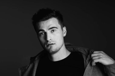 Stüdyoda poz veren ceketli genç yakışıklı adam. 