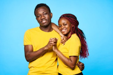 Stüdyoda mavi arka planda poz veren genç ve güzel bir çift