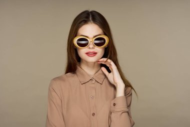 Stüdyoda poz veren güneş gözlüklü güzel bir kadın. 