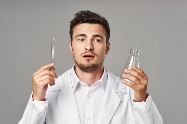 confused  Doctor in lab coat with test tubes