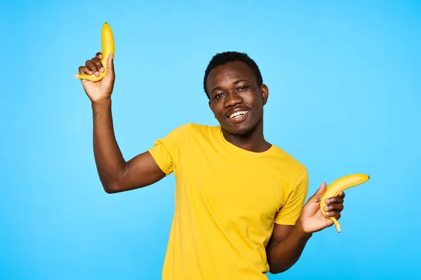 Young man with bananas    isolated on blue background