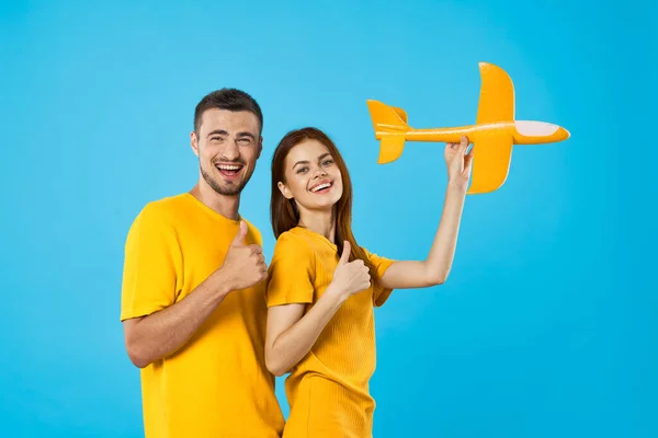 Jong Mooi Paar Spelen Met Geel Speelgoed Vliegtuig Blauwe Achtergrond — Stockfoto