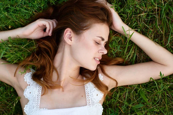 年轻漂亮的女人躺在草地上 — 图库照片