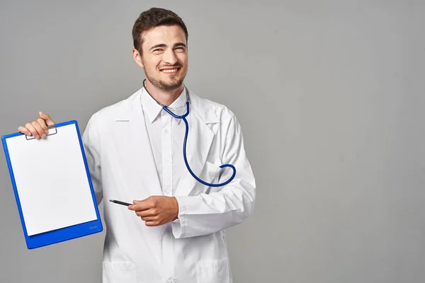 Tiro Estúdio Jovem Médico Mostrando Área Transferência Isolada Fundo Cinza — Fotografia de Stock