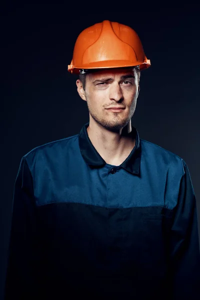 young man in work wear and helmet. Studio shot