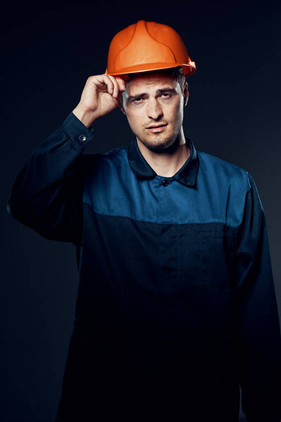 young man in work wear and helmet. Studio shot