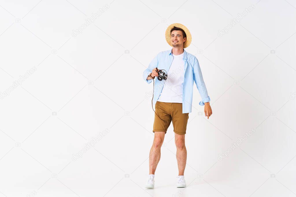 young handsome man tourist with camera in studio
