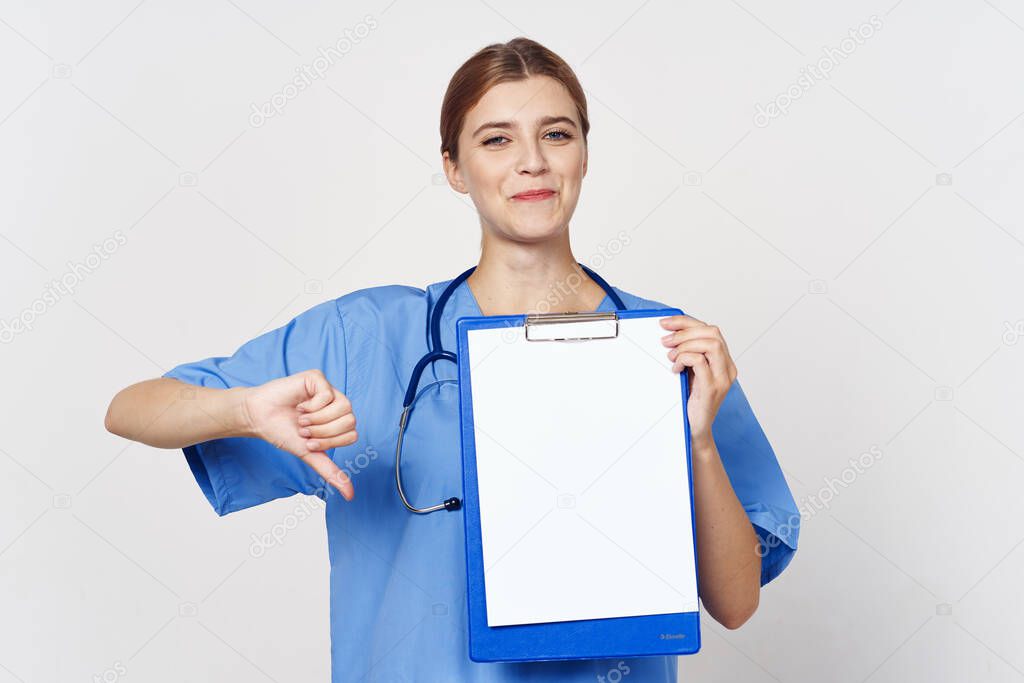 Studio shot. Young woman doctor with document  showing thumb down  on isolated background