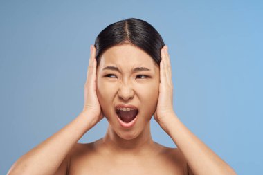 Stüdyo çekimi. Genç Asyalı kadın çığlık atıyor.  