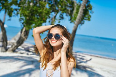 Genç ve güzel bir kadın sahilde dinleniyor.