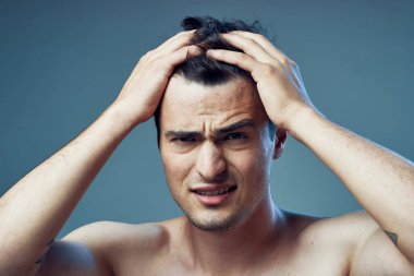 Stüdyo çekimi. Modern saç stili olan genç yakışıklı bir adam stüdyoda poz veriyor. 