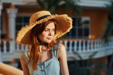   Tropik tatil köyünde hasır şapkalı genç bir kadın. 