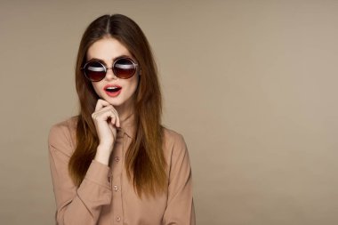 Stüdyoda poz veren güneş gözlüklü güzel bir kadın. 