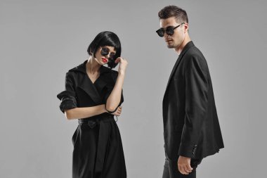 Siyah elbiseli genç çift stüdyoda poz veriyor.