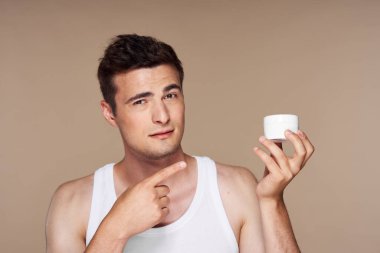 Stüdyo. Güzellik ürünleriyle genç yakışıklı adam.