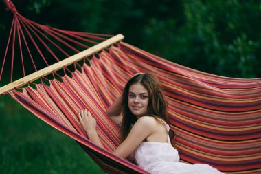 Genç ve güzel bir kadın hamakta dinleniyor. 