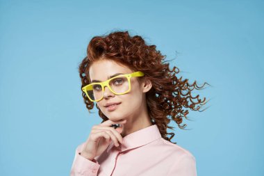 Stüdyoda poz veren gözlüklü güzel bir kadın.