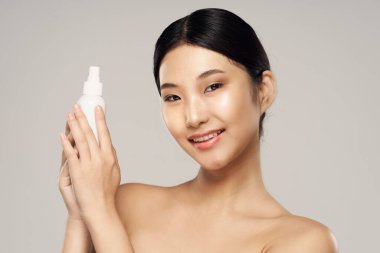 Stüdyo çekimi. Genç Asyalı kadın portresi ve güzellik ürünü.
