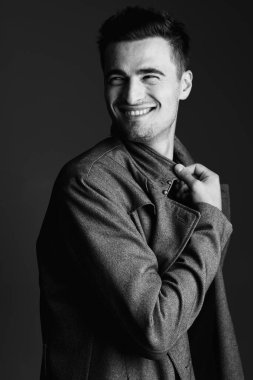 Stüdyo çekimi. Poz veren genç yakışıklı adamın portresi.