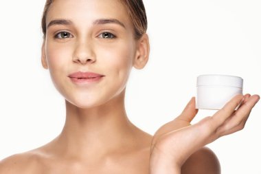 Genç ve güzel bir kadın krem tutuyor. 