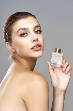 Parfüm şişeli güzel bir kadının portresi. Stüdyo çekimi.  