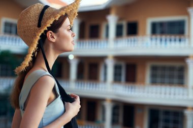   Tropik tatil köyünde hasır şapkalı genç bir kadın. 