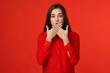 Stüdyo çekimi. Kırmızılı güzel kadın kırmızı arka planda izole edilmiş.