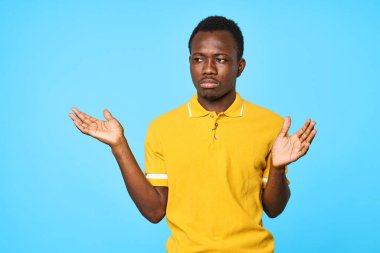 Stüdyoda poz veren yakışıklı genç adam mavi arka planda izole edilmiş.