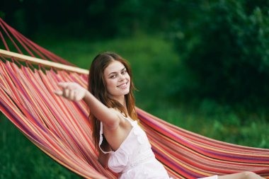 Genç ve güzel bir kadın hamakta dinleniyor.