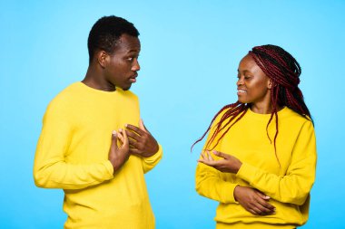 Stüdyoda mavi arka planda poz veren genç ve güzel bir çift