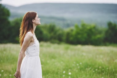 Kırsalda poz veren genç bir kadın. 