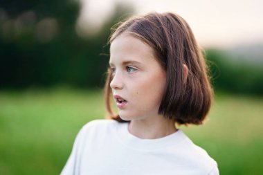 Genç tatlı kız çayırda eğleniyor.