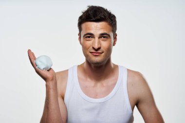 Stüdyo çekimi. Tıraş köpüğü olan yakışıklı bir genç. 