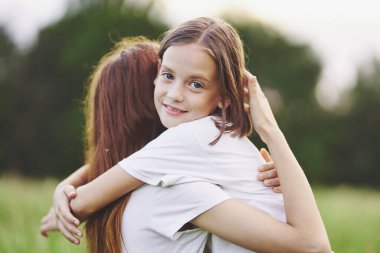 Genç anne ve kızı papatya tarlasında eğleniyorlar.